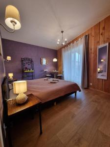 a bedroom with a bed and a table with a lamp at Les Chambres d'Anna in Royer