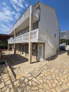 a large white building with a balcony on it at Olive Luxury Apartments Orebić in Orebić