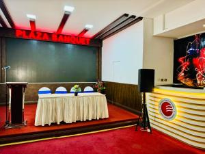 a meeting room with a table and a stage at Fortune Plaza Hotel, Dubai Airport in Dubai +37 photos