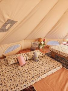 a room with two beds in a tent at Kubo ni Apple in Tagbina