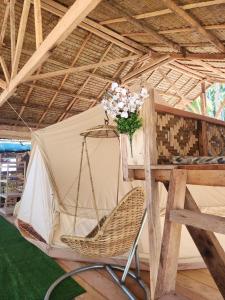 a chair in a tent with a vase of flowers at Kubo ni Apple in Tagbina