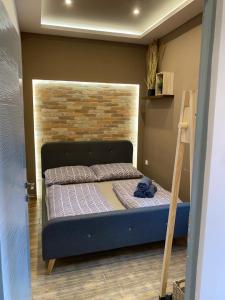 Bett in einem Zimmer mit Ziegelwand in der Unterkunft The Loft Apartman Szeged in Szeged