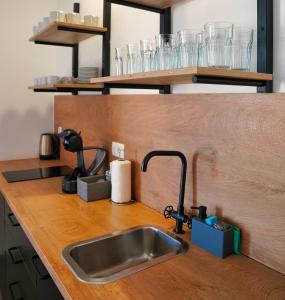 encimera de cocina con fregadero y estanterías con vasos en Aroma apartments, en Liubliana 22 fotos más