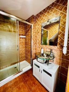 ein Badezimmer mit einem Glaswaschbecken und einer Dusche in der Unterkunft Su Casita Marinera in Escarabote