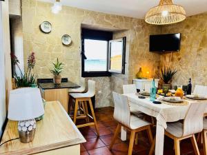 eine Küche und ein Esszimmer mit Tisch und Stühlen in der Unterkunft Su Casita Marinera in Escarabote + 23 Fotos