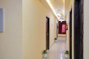 a hallway with two potted plants in a building at Hotel O Moon Hotel in Ghaziabad
