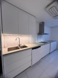 a kitchen with white cabinets and a sink at House in Årnes