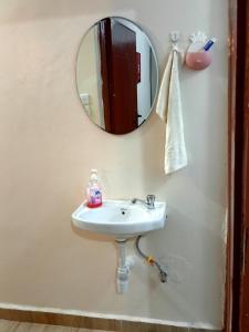a bathroom with a sink and a mirror at Cozy 1BR Apartment along Eldoret-Kisumu road close to Eldoret Polytechnic and Elgon View Hospital in Eldoret