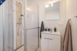 ein weißes Badezimmer mit Dusche und Waschbecken in der Unterkunft Heimathafen An Seen & Meer in Korswandt