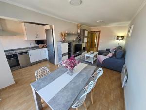 Una cocina y una sala de estar con mesa y sillas. en Apartamento Nara Playa, en Boiro