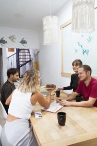ラスパルマス・デ・グランカナリアにあるAgüita Surf Lodgeのテーブルの周りに座っている人々のグループ