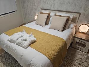 Un dormitorio con una cama grande con toallas. en Apartamento Nara Playa, en Boiro