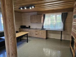 a kitchen with a wooden table and a window at Bona Natura Pirtelė in GratiÅ¡kÄ—s