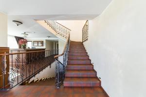 a staircase in a home with white walls and wooden floors at Motel Panorama in Šiauliai