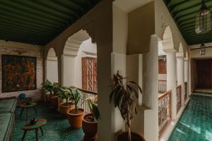 a lobby with a swimming pool and plants at Riad Senja in Marrakesh