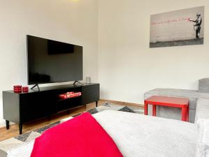 a living room with a flat screen tv on a wall at Banksy Apartment - Art & Fun mit 2 Balkonen - 6 Betten in Hannover