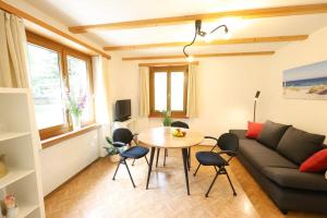a living room with a couch and a table at Chasa Betty - Im Garten der drei Länder in Martinsbruck