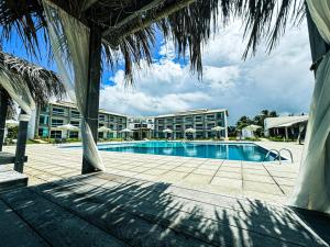 a resort swimming pool with a hotel in the background at Eco Privillege Hotel in Pacatuba