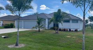 The Salt Life Get Away - Cape Coral, Florida في كيب كورال: منزل به نخلتين في الفناء