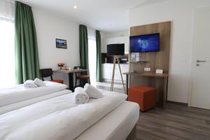une chambre d'hôtel avec deux lits et une télévision dans l'établissement Holledau-Apartments, Apartments für 1-5 Pers, getrennte Betten, Vollausstattung, kurze u lange Aufenthalte, 24h Checkin, wöchentl Reinigung u Wäschewechsel, Waschmaschine u Trockner, WLAN, XXL Parkplätze, Garten, ruhige Lage, gute Autobahnanbindung, à Osterwaal 26 autres photos