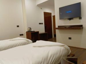 a hotel room with two beds and a flat screen tv at Enso Boutique Stay in Leh +28 photos