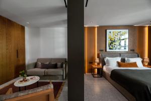 ein Hotelzimmer mit einem Bett und einer Couch in der Unterkunft The Editor Hotel Athens in Athen