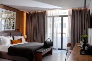 ein Schlafzimmer mit einem Bett und einem großen Fenster in der Unterkunft The Editor Hotel Athens in Athen