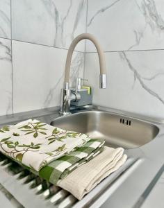 a kitchen sink with two towels on a towel rack at Libás Apartman in Keszthely +25 photos