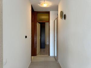 a hallway with white walls and wooden doors at Apartman Terrazza in Sumartin