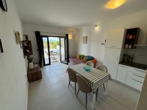 a kitchen and dining room with a table and chairs at Apartman Terrazza in Sumartin