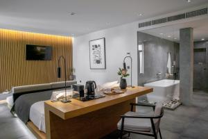 Schlafzimmer mit einem Bett und einem Schreibtisch mit einer Mikrowelle in der Unterkunft The Editor Hotel Athens in Athen