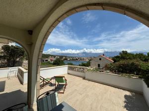 a balcony with chairs and a view of the water at Apartman Terrazza in Sumartin