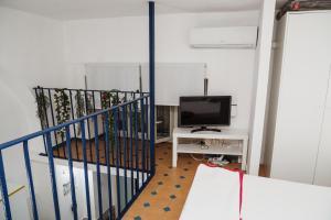 a living room with a staircase with a tv and a tvictericterictericter at Perla Azzurra in Catania +24 photos