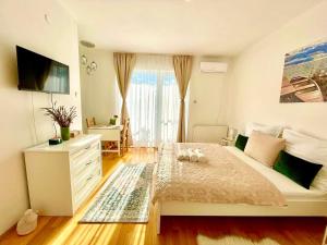 a bedroom with a bed with a dresser and a window at Libás Apartman in Keszthely