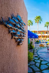 una scultura di pesce sul lato di un muro di Hotel Los Patios a Cabo San Lucas
