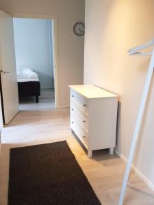una camera con cassettiera bianca e una camera da letto di Kotimaailma Apartments - 1BR in city center of Turku a Turku