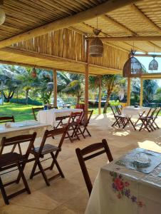 a group of tables and chairs in a pavilion at Nascer do Sol Kitesurf House in Fortim
