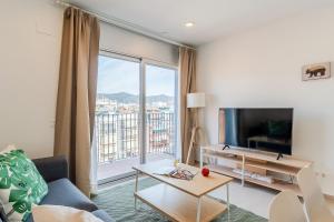 a living room with a tv and a large window at 4238 - AB Duplex Santa Coloma III in Santa Coloma