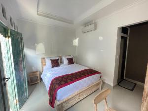 una camera da letto bianca con un letto e una sedia di Nivaluma ad Ubud