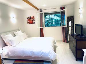 a bedroom with a white bed and a window at Appartement au calme avec terrasse verdoyante entre Annecy et Genève in Villy-le-Pelloux