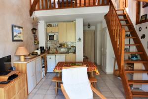 a kitchen with a table and a spiral staircase at Charming duplex of 40m2 with view on the valley in Saint-Chaffrey