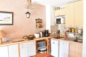 a kitchen with white cabinets and a microwave at Charming duplex of 40m2 with view on the valley in Saint-Chaffrey