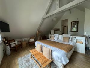 蓬托尔松L'Orée du Mont proche du mont saint Michel的阁楼里有一张大床的卧室