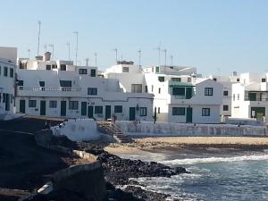 un gruppo di edifici bianchi vicino all'oceano di Caleta Caballo Beach a Caleta de Caballo
