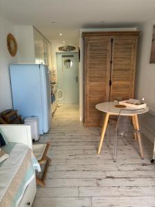 una cocina con una mesa y un refrigerador en Studio cosy en bord de mer, en Sangatte