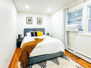 a bedroom with a bed and a window at Lux Designer Home with Gaming Rm in Jersey City +26 photos