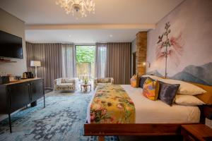 a bedroom with a large bed and a chandelier at Droombos Boutique Hotel in Windhoek