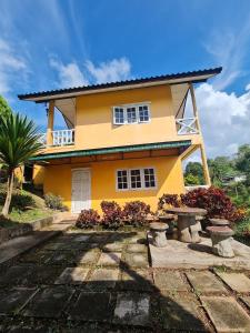 a yellow house with a bench in front of it at ภูม่านฟ้ารีสอร์ทและลานกางเต็นท์เขาค้อ in Khao Kho