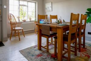 a dining room with a wooden table and chairs at Riverside Cottage in Tewkesbury