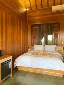 Ein Bett oder Betten in einem Zimmer der Unterkunft Putra'Lebah Amed Guest House